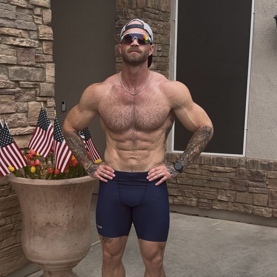The coach stands with hands on his hips outside his home.